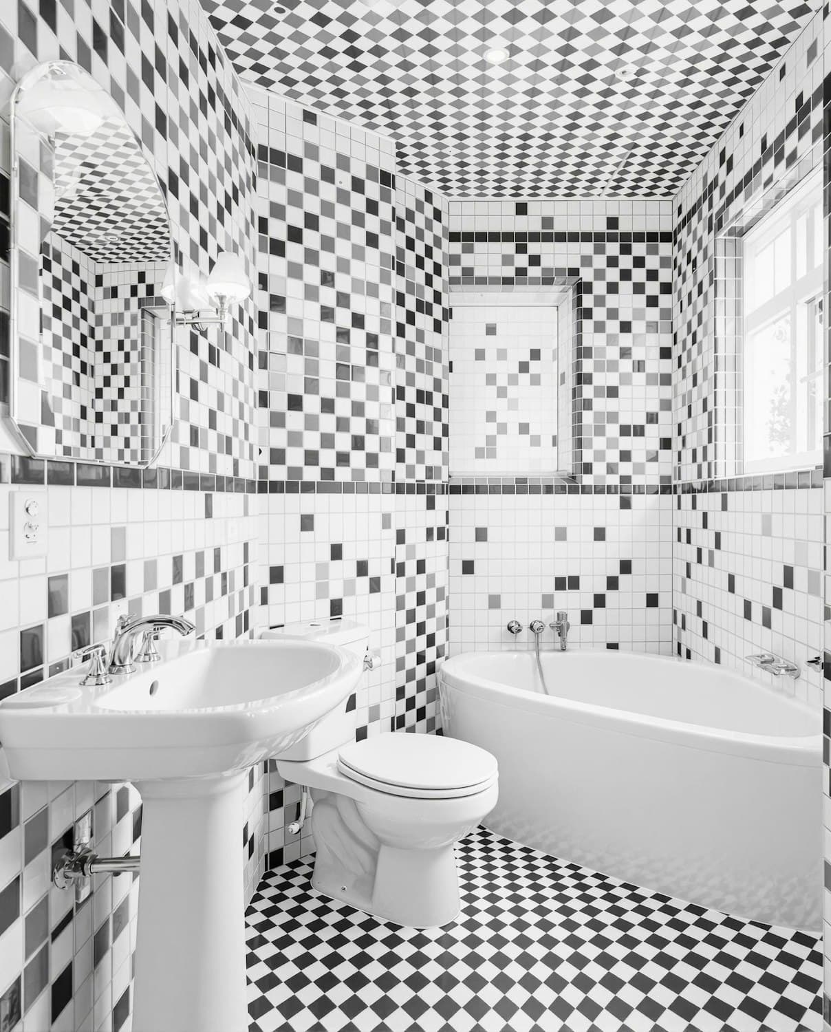 Bathroom finished in a black and white checkered tile floor with a curved tub